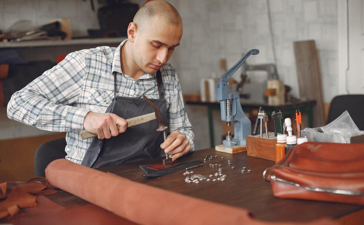 Man in a studio creates leather ware