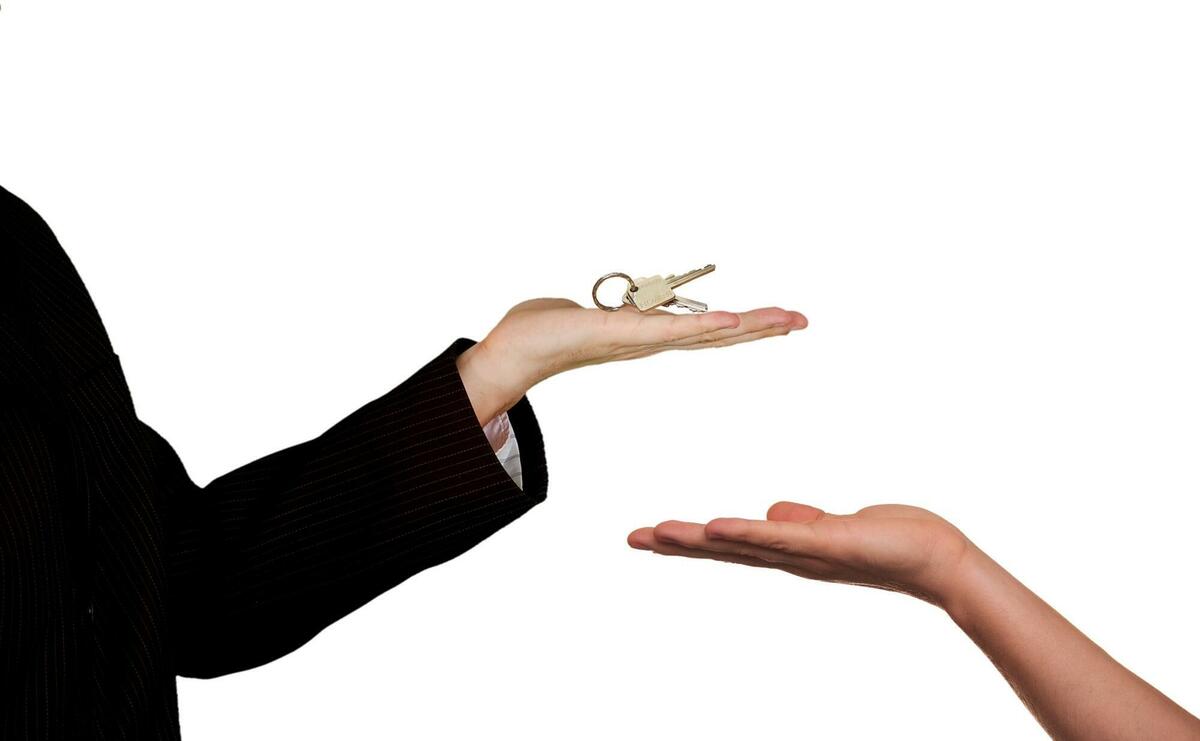 One person is giving keys to an other.