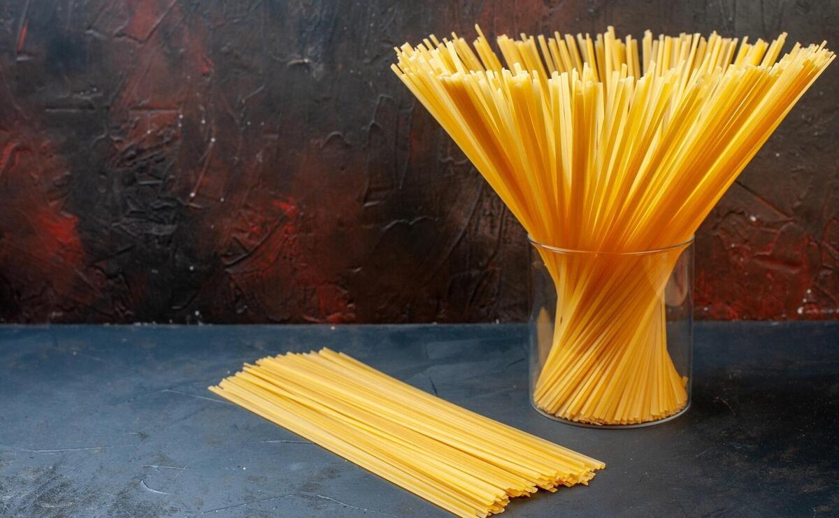 Front view bundle of spaghetti in glass on dark background