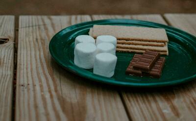 Crackers and chocolates in round green ceramic plate.