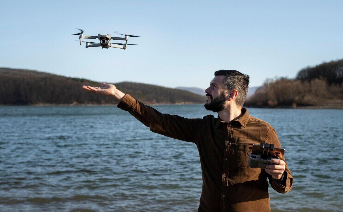 Medium shot man with drone outdoors