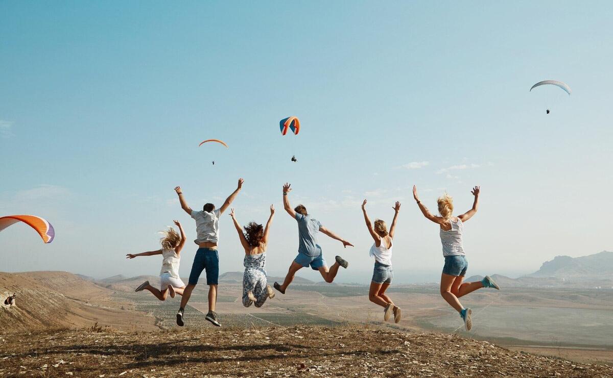 Group of friends jumping on top of hill