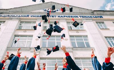 College students throw their hats into the air.