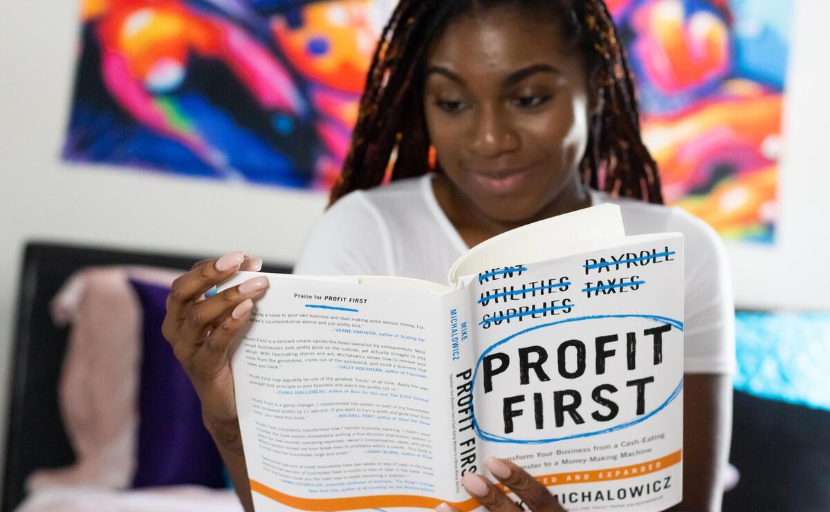 A woman reads the Profit First book.