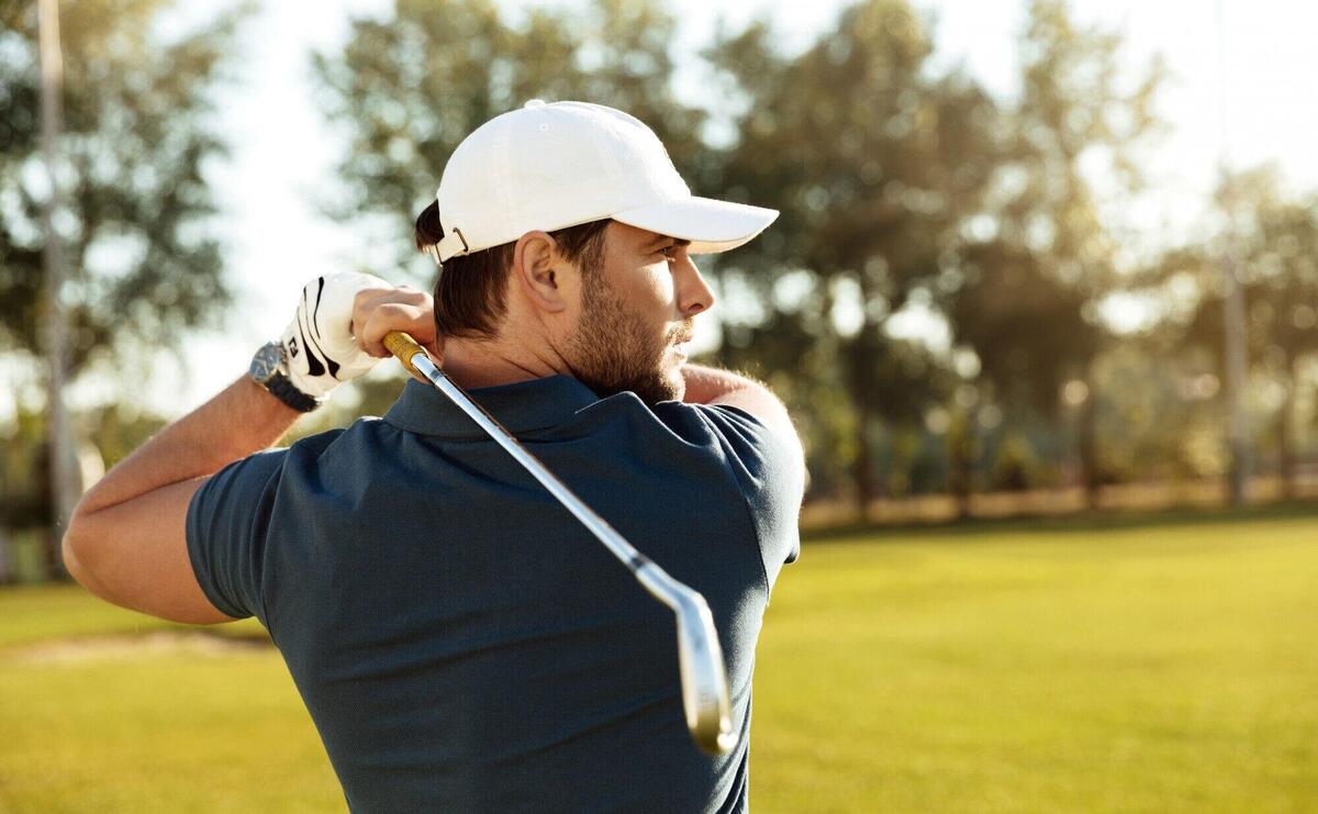Close up of a young concentrated man shooting golf ball