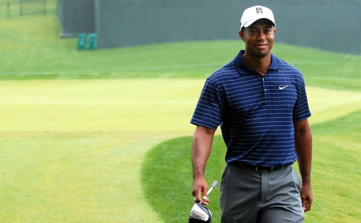 Tiger Woods walking with a golf club.