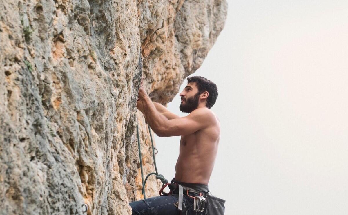Strong man climbing on a mountain
