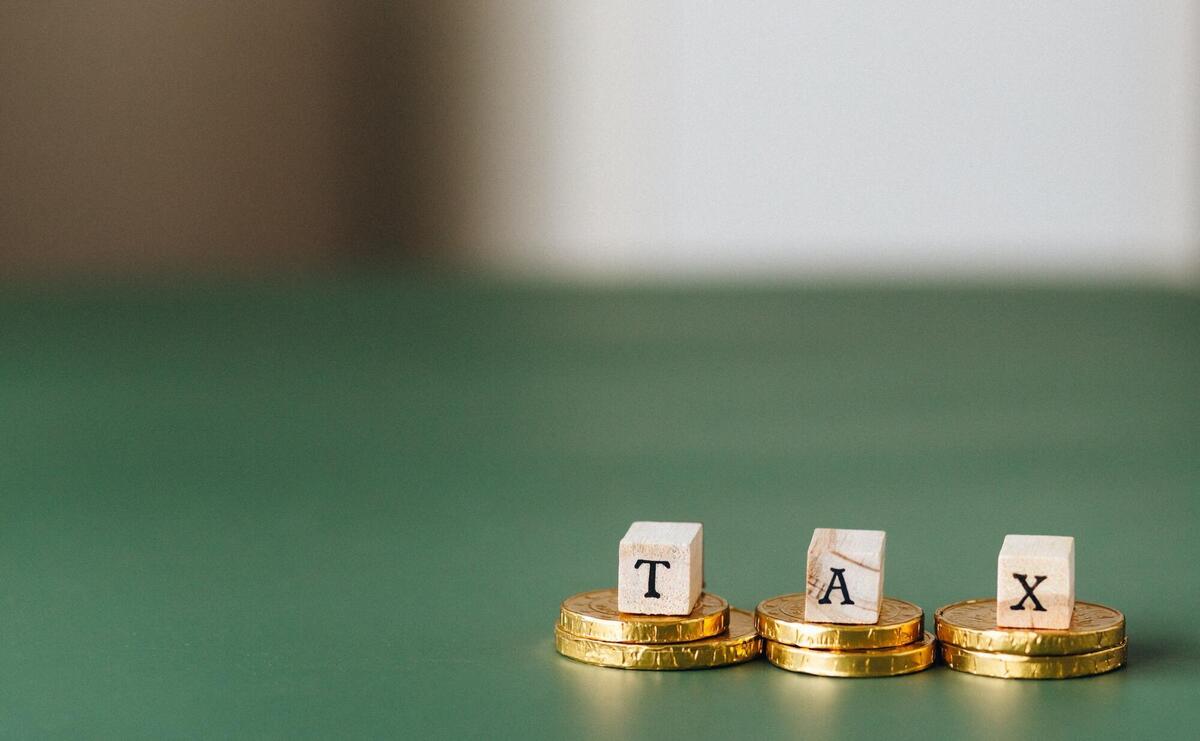 Tax word on top of gold coins