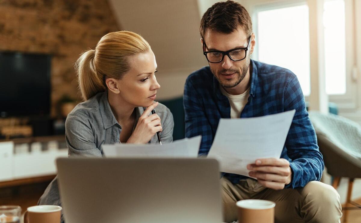 Young couple analyzing their budget while going through home finances
