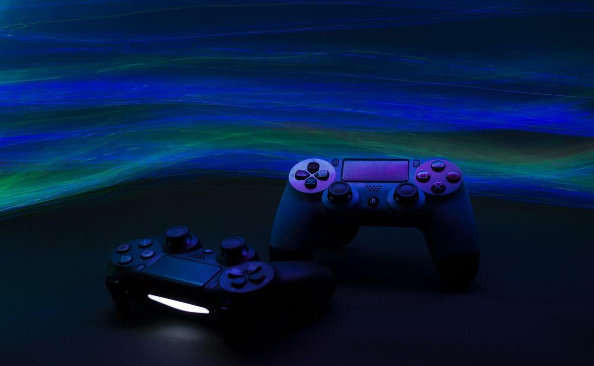 Two playstation controllers in the dark.