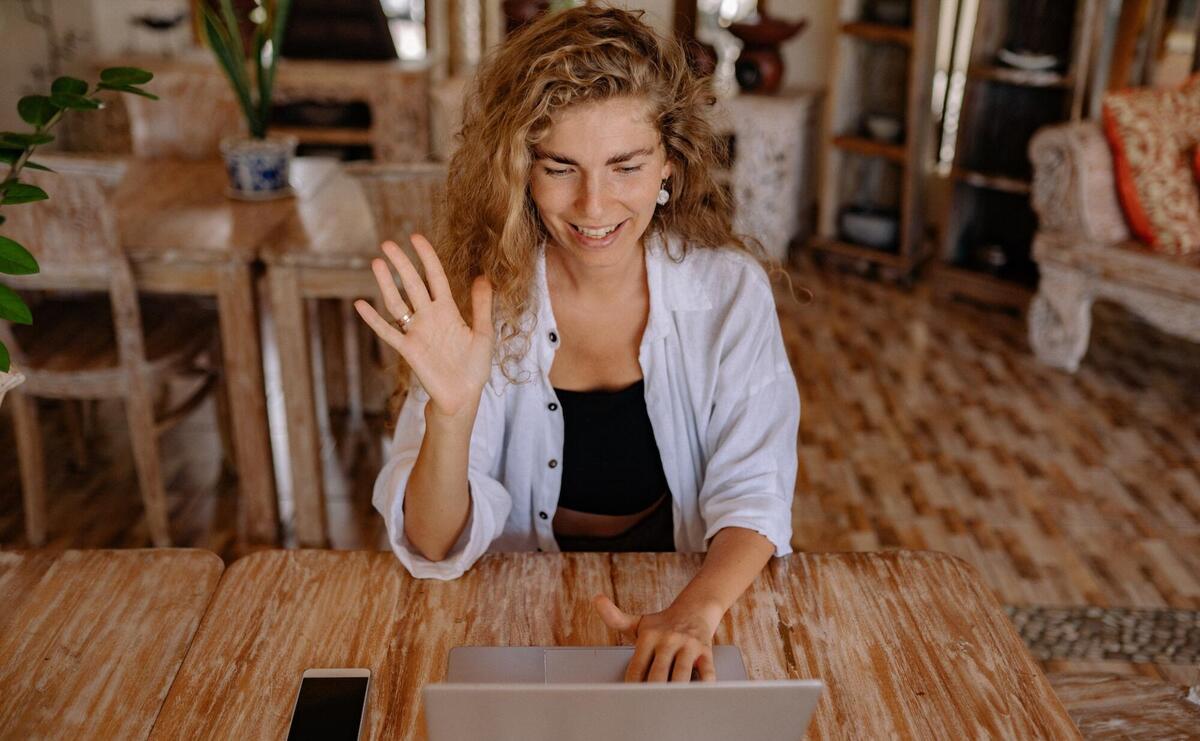 A woman is weaving her hand in front of her computer.