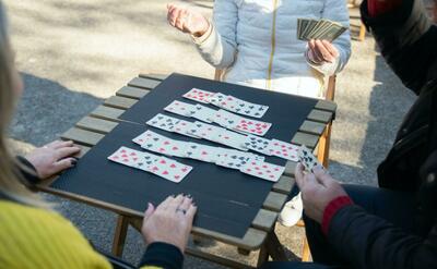 A group playing solitaire outdoors.