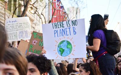 Person holding there is no planet B poster.