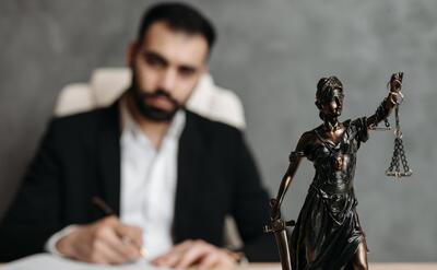Lawyer behind a Lady Justice figure.