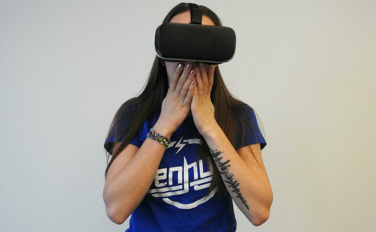 A yound woman is using a VR headset.