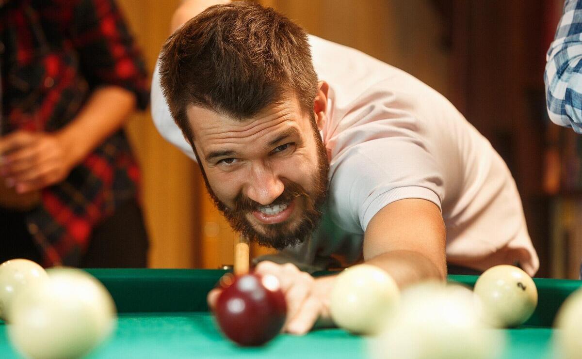 Close-up shot of a man playing billiard