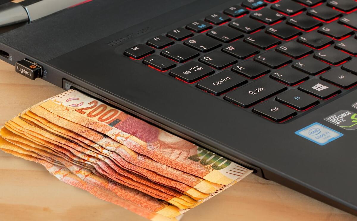 Illustration of money coming out from a laptop.